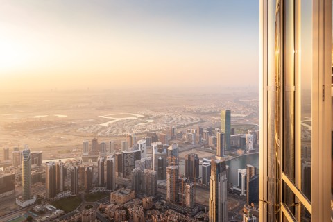 Ausblick vom Burj Khalifa in Dubai, herab auf die Stadt, bei untergehender Sonne..