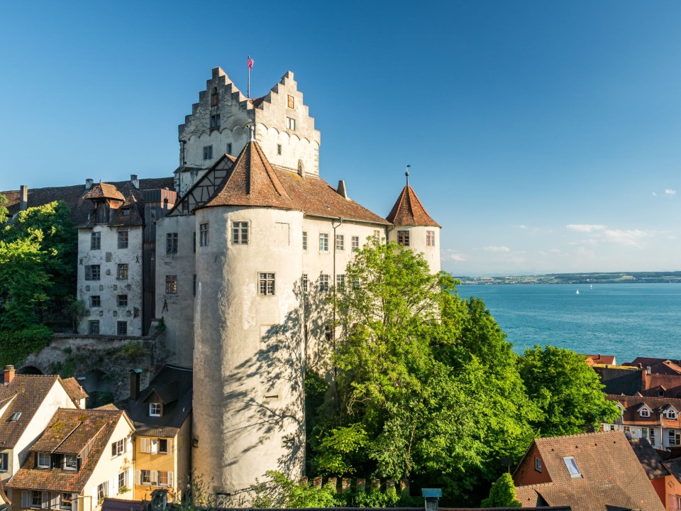 Burg Meersburg vor dem Bodensee und blauem Himmel.____
