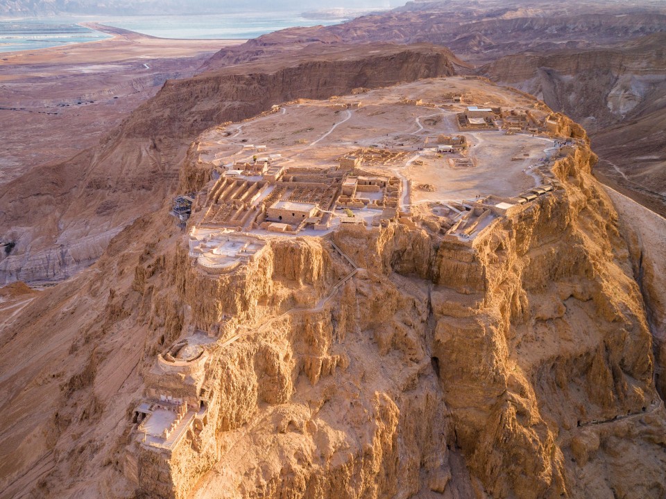 Die Festung Masada auf einem rötlichen Felsen mit Steilhängen.____