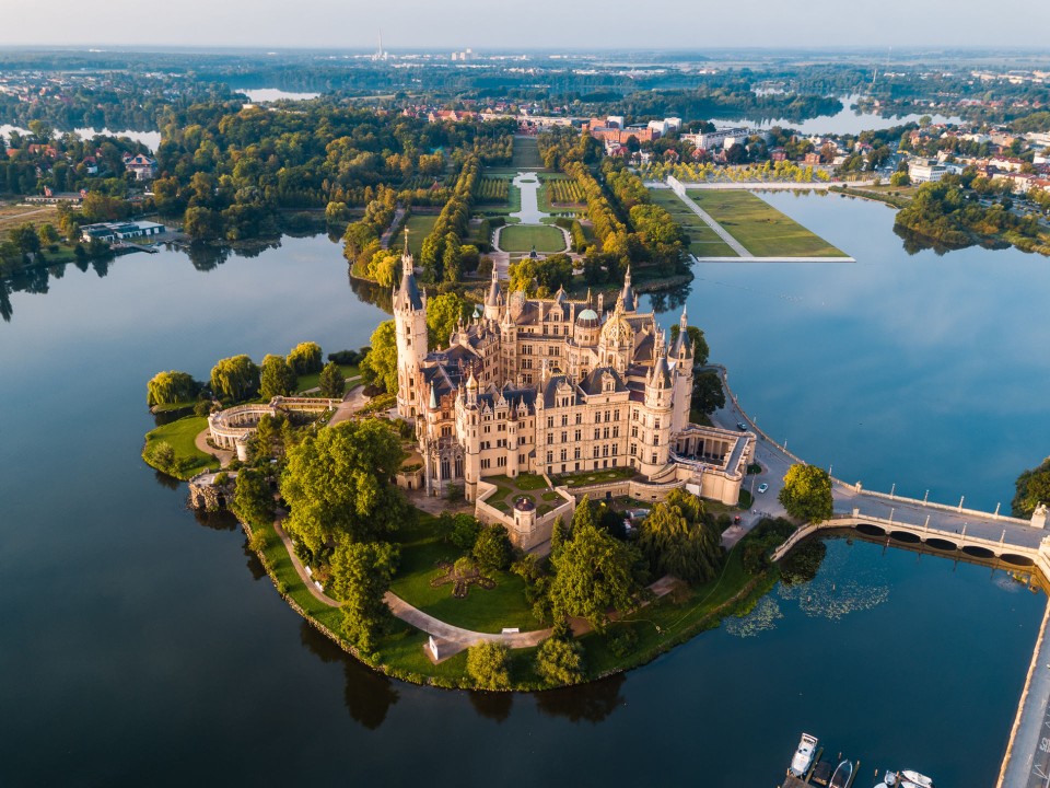 Schloss Schwerin auf einer grün bewachsenen Insel, ringsherum Wasser.____